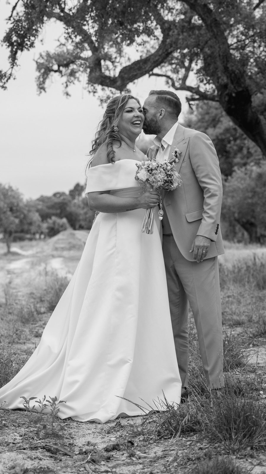 Noivos a preto e branco entre oliveiras, reportagem de casamento